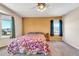 Cozy bedroom featuring neutral carpet, ceiling fan, and abundant natural light through large windows at 8871 W Maryland Ave, Glendale, AZ 85305