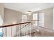Upstairs hallway with neutral walls and carpet and traditional wood trim at 8871 W Maryland Ave, Glendale, AZ 85305