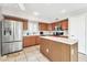 Spacious kitchen boasts stainless steel appliances, tile flooring, a kitchen island, and ample counter space at 8871 W Maryland Ave, Glendale, AZ 85305