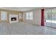 Cozy living room with a traditional tile fireplace, neutral tile floor, and a sliding glass door to the backyard at 8871 W Maryland Ave, Glendale, AZ 85305