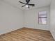 This is a bright bedroom with a ceiling fan, wood floors, and a window at 9343 W Harmony Ln, Peoria, AZ 85382