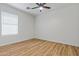 This is a bright bedroom with a ceiling fan, wood floors, and a window at 9343 W Harmony Ln, Peoria, AZ 85382