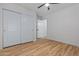 This is a bright bedroom with a ceiling fan, wood floors, and a closet at 9343 W Harmony Ln, Peoria, AZ 85382