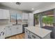 Bright kitchen featuring white cabinets, stainless steel appliances, and a quartz countertop island with wood flooring at 9343 W Harmony Ln, Peoria, AZ 85382