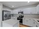 Modern kitchen featuring white cabinets, stainless steel appliances, and quartz countertops at 9343 W Harmony Ln, Peoria, AZ 85382