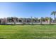 Fenced in Community pool surrounded by green grass and mature trees at 943 E Kortsen Rd # 2, Casa Grande, AZ 85122