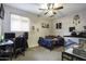 Bedroom featuring a ceiling fan, window, bed, desk, and reptile terrarium at 943 E Kortsen Rd # 2, Casa Grande, AZ 85122