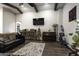 Living room with a large sectional couch, hardwood floors, exposed beams, a ceiling fan, and decor at 943 E Kortsen Rd # 2, Casa Grande, AZ 85122