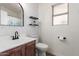 Bathroom with modern finishes including stylish wallpaper, floating shelves, and updated fixtures at 1058 W Swan Dr, Chandler, AZ 85286