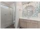 Stylishly decorated bathroom with modern fixtures, a glass-enclosed shower, and leaf patterned wallpaper at 1058 W Swan Dr, Chandler, AZ 85286