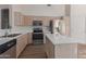 Modern kitchen with stainless steel appliances, light wood cabinets, and white countertops at 1058 W Swan Dr, Chandler, AZ 85286