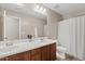 Well-lit bathroom with double sinks and a shower, offering convenience and style at 11129 E Reginald Ave, Mesa, AZ 85212