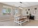 A dining room features a wooden table with bench seating, artwork, and natural light from multiple windows at 11129 E Reginald Ave, Mesa, AZ 85212