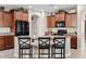 A lovely kitchen features a large island with seating, granite countertops, and brown cabinets at 11129 E Reginald Ave, Mesa, AZ 85212
