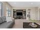 Living room with large windows, comfortable gray sofa, and a wooden entertainment center at 11129 E Reginald Ave, Mesa, AZ 85212