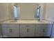 Bathroom featuring a dual-sink vanity, white cabinetry and two mirrors at 11796 N Vanero Ct, Maricopa, AZ 85139