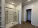 Bathroom showcases a glass-enclosed shower, shelving, and light wood-look tile flooring at 11796 N Vanero Ct, Maricopa, AZ 85139