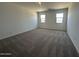 Bright bedroom features neutral carpet and two windows at 11796 N Vanero Ct, Maricopa, AZ 85139