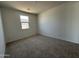 Bright carpeted bedroom with a single window and neutral walls, providing a blank canvas at 11796 N Vanero Ct, Maricopa, AZ 85139