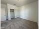 Bedroom with neutral carpet, open doorway, and closet with sliding doors at 11796 N Vanero Ct, Maricopa, AZ 85139