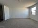 Large carpeted bedroom with bright neutral walls and a window; blank canvas ready for personalization at 11796 N Vanero Ct, Maricopa, AZ 85139