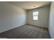 This cozy carpeted bedroom features a window letting in natural light and neutral walls at 11796 N Vanero Ct, Maricopa, AZ 85139