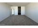 Carpeted room with a doorway shows an entryway with hard-surface flooring, neutral walls and ceiling at 11796 N Vanero Ct, Maricopa, AZ 85139