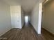 Bright hallway with wood-look tile flooring leading to rooms filled with natural light at 11796 N Vanero Ct, Maricopa, AZ 85139