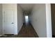 Bright hallway with wood-look tile flooring leading to a living area at 11796 N Vanero Ct, Maricopa, AZ 85139