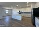 The kitchen has wood look flooring, a center island, white cabinets and stainless steel appliances at 11796 N Vanero Ct, Maricopa, AZ 85139