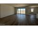 Bright living room with wood look flooring, neutral walls, and sliding glass doors to the backyard at 11796 N Vanero Ct, Maricopa, AZ 85139