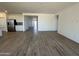 Spacious living area with wood-look tile flooring leads into the kitchen and dining areas at 11796 N Vanero Ct, Maricopa, AZ 85139