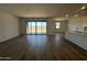 Bright living room with wood look flooring, neutral walls, and sliding glass doors to the backyard at 11796 N Vanero Ct, Maricopa, AZ 85139