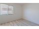 Bedroom features neutral walls, wood-look floors and large window at 11805 W Sunnyside Dr, El Mirage, AZ 85335