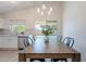Bright dining area with view of pool, features sliding glass door and modern light fixture at 11805 W Sunnyside Dr, El Mirage, AZ 85335
