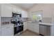White kitchen cabinets and stainless appliances brighten the kitchen with lots of counter space at 11805 W Sunnyside Dr, El Mirage, AZ 85335