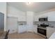 Bright kitchen boasts white cabinets, stainless steel appliances, and tile flooring at 11805 W Sunnyside Dr, El Mirage, AZ 85335