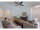 Spacious living room featuring comfortable seating, wood flooring, and modern ceiling fan at 11805 W Sunnyside Dr, El Mirage, AZ 85335