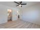 Bright main bedroom features wood-look floors, ceiling fan, and ensuite bathroom at 11805 W Sunnyside Dr, El Mirage, AZ 85335