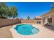 A backyard featuring a free form pool and desert landscaping, alongside a covered patio at 11805 W Sunnyside Dr, El Mirage, AZ 85335