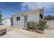 View of the backyard exterior with a brick home, small storage shed, and small flower bushes at 120 S Olive --, Mesa, AZ 85204