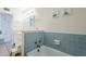 Bathroom featuring a light blue tiled bathtub with white fixtures, a tiled half-wall, and a vanity nearby at 120 S Olive --, Mesa, AZ 85204