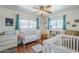 Bright bedroom featuring hardwood floors, two white cribs, and windows with blue curtains at 120 S Olive --, Mesa, AZ 85204