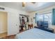 Bright bedroom features a ceiling fan, closet, light blue bedding, and window with teal curtains at 120 S Olive --, Mesa, AZ 85204