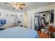 Bedroom featuring hardwood floors, a blue bedspread, a desk, and a closet with a mirror sliding door at 120 S Olive --, Mesa, AZ 85204