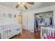 Bright bedroom featuring hardwood floors, a white crib, and an open closet with shelving and hanging storage at 120 S Olive --, Mesa, AZ 85204