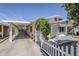 Exterior view of the home with covered parking, white picket fence, and decorative plants at 120 S Olive --, Mesa, AZ 85204