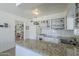 Spacious kitchen boasting white cabinetry, stainless steel appliances and island countertops flowing into the dining area and study at 120 S Olive --, Mesa, AZ 85204