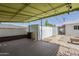Covered patio with a wooden deck, string lights, storage, and access to the backyard and the main house at 120 S Olive --, Mesa, AZ 85204