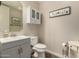 Charming half bathroom with white vanity, storage cabinet, wood-look floors, and delightful decor at 1217 W Fever Tree Ave, San Tan Valley, AZ 85140